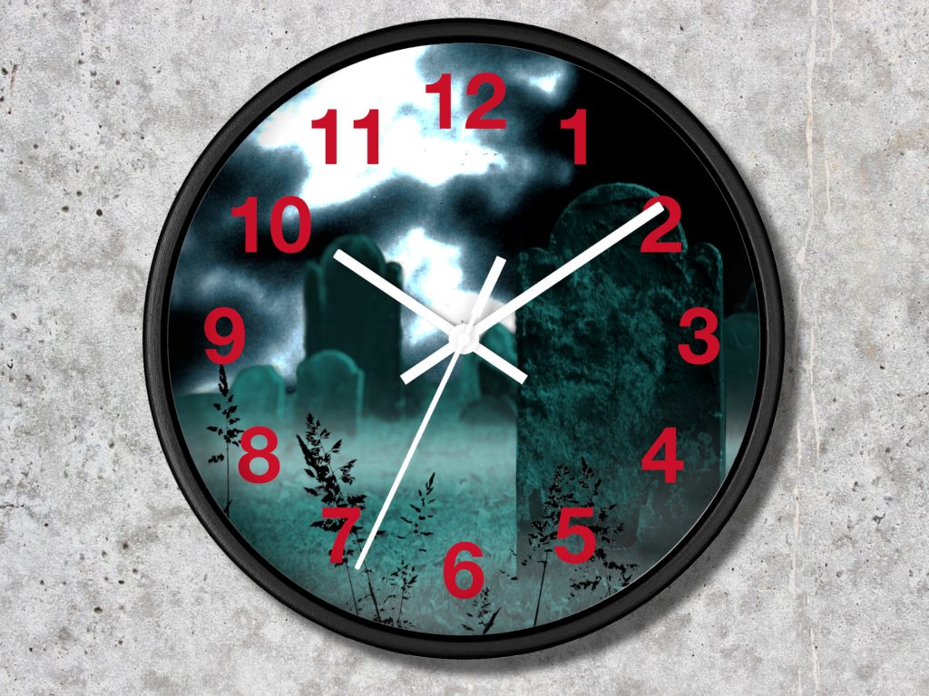 Clock with a cemetery design. Red numbers and white hands overlay a spooky graveyard under a cloudy night sky, creating an eerie atmosphere.