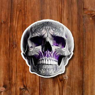 Ornate black-and-white skull sticker with purple accents on a warm wooden plank background, creating a dark gothic, dramatic mood.