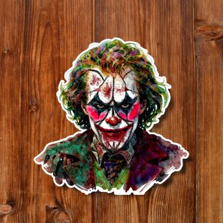 Colorful creepy horror clown sticker with wild green hair, white face paint, red grin, and purple coat on a rustic wooden background.