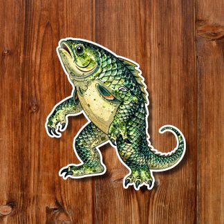 Illustrated green fish monster sticker with scales, curled tail, and raised claws, posed playfully against a warm wooden plank background.