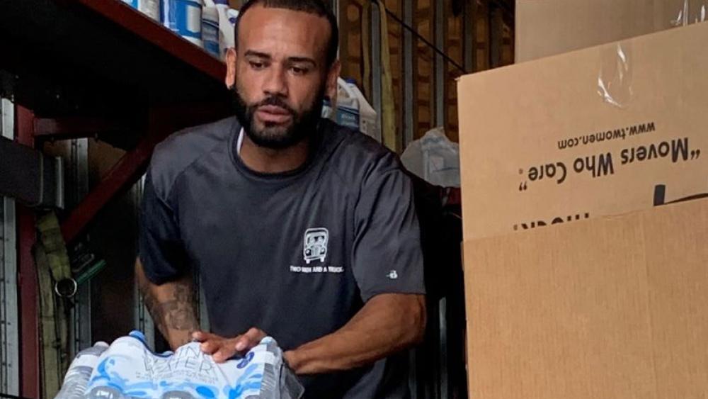 mover with two men and a truck unloading supplies for the bahamas relief