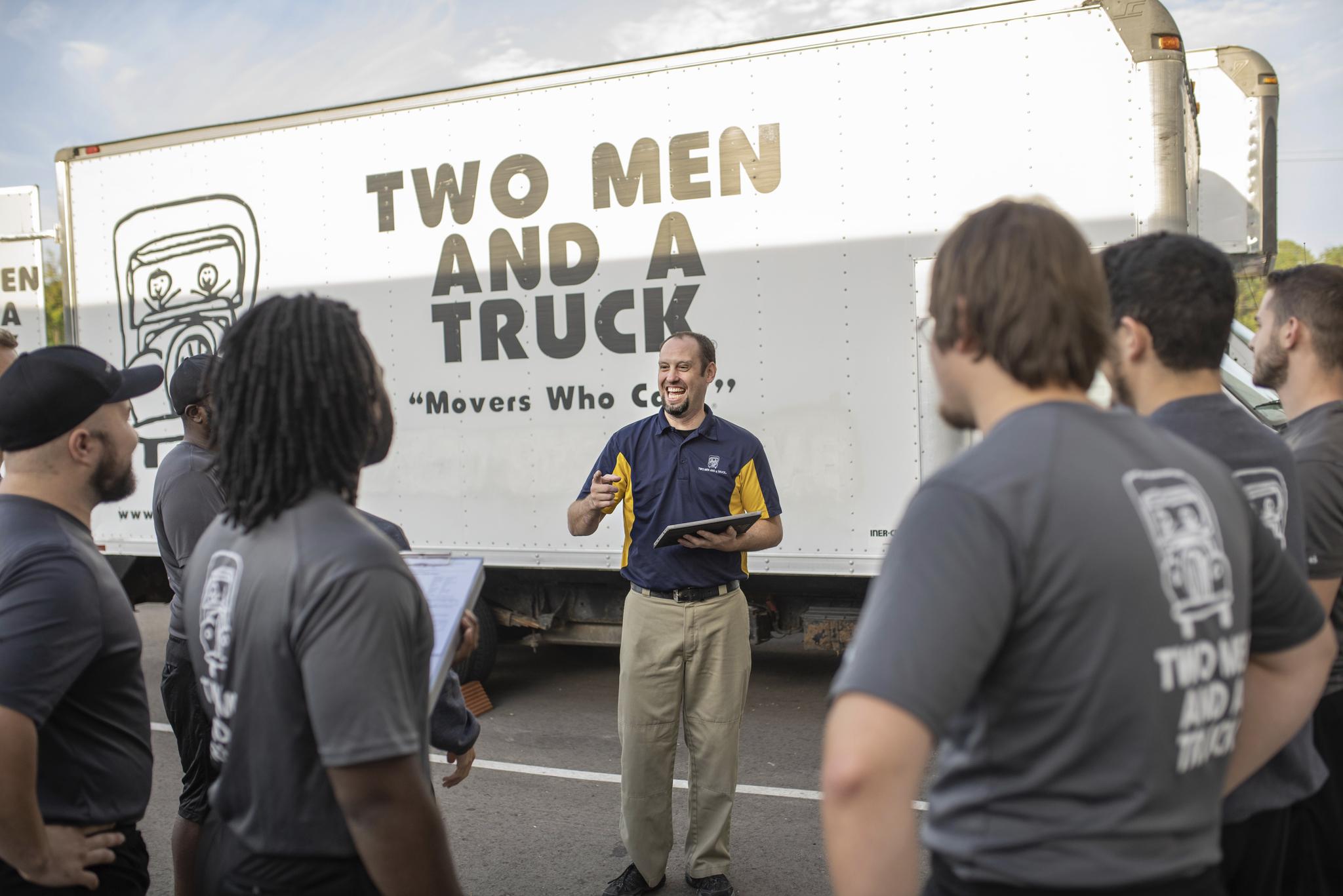 Manager giving instructions to the move team outside beside a truck