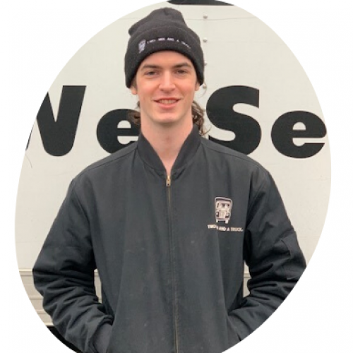 Ben Gebolys standing in front of a truck with his hands in his front pockets wearing a winter beanie
