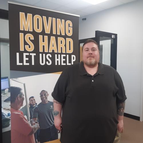 James posing in front of a banner in the office