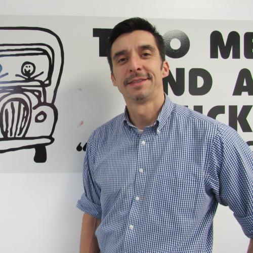 Office Assistant, Davis Jao, standing in front of our Truckie logo!