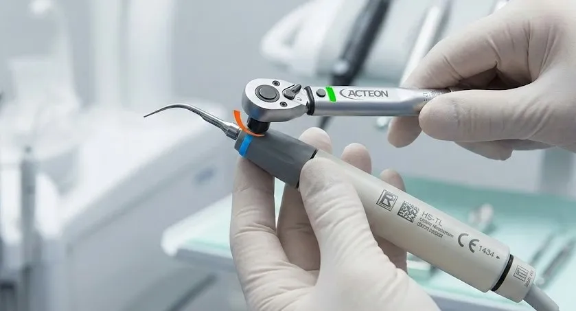 close-up-of-an-acteon-ultrasonic-scaler-handpiece-with-a-universal-tip-being-tightened-using-a-torque-wrench-highlighting-correct-torque-application.webp
