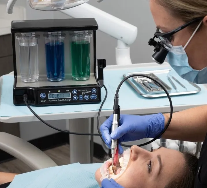 dentist-using-a-denmat-ultrasonic-scaler-with-the-cable-comfortably-positioned-and-connected-to-the-unit-during-a-procedure..webp