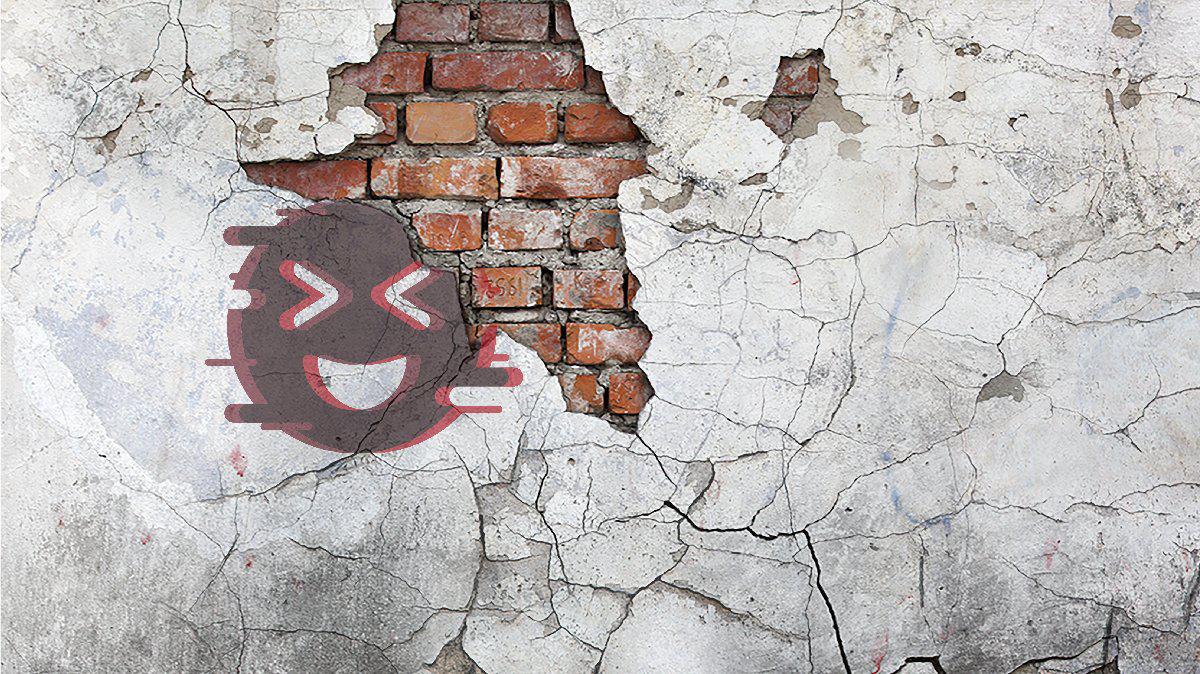Cracked brick wall with graffiti smiley face