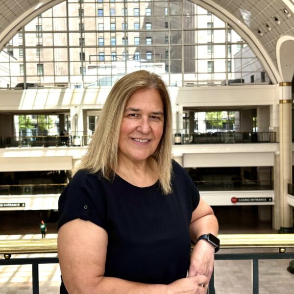 Photo of Pandemonium Honore Deb Janik posing in front of a business backdrop.