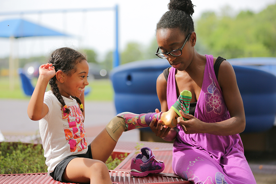 Audrey McFadden on a playground with her mother, Clarissa. Prosthetic. Family.
