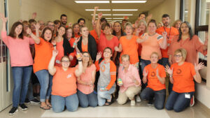 Summit DD Group Photo wearing orange t-shirts