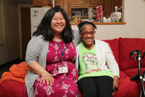Young African American woman seated next to her SSA, Yunyoung, smiling.