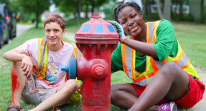 Two teens, Noah and Zaria, painting fire hydrants in Stow for the 2022 Summer Youth Work Program.