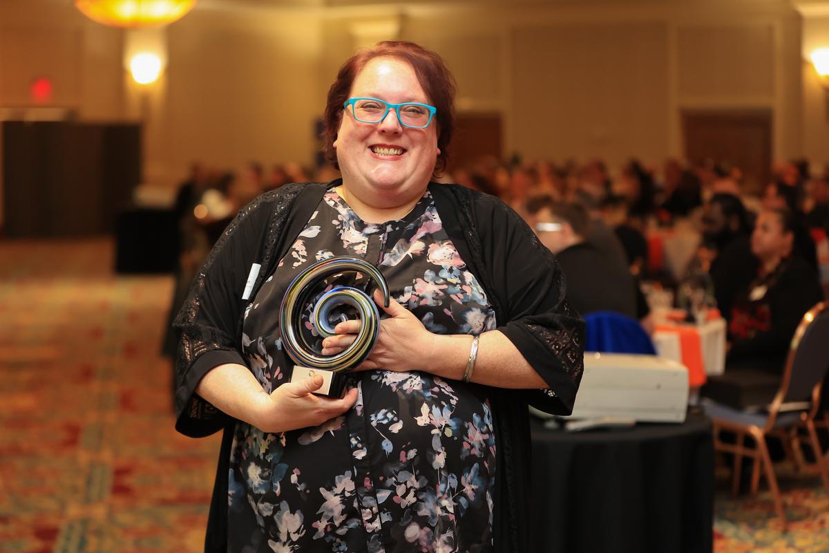 Melanie Zaidman holding her award trophy at Summit DD's 2023 Appreciation Breakfast and Awards Celebration