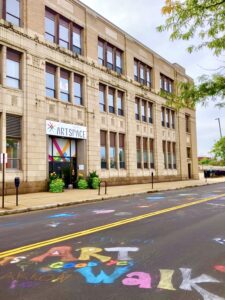 Summit Art Space's physical building with chalk writing that says ART WALK" on the road in front of the building.