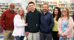 Photo a a young man named Max and his team of developmental disabilities professionals.
