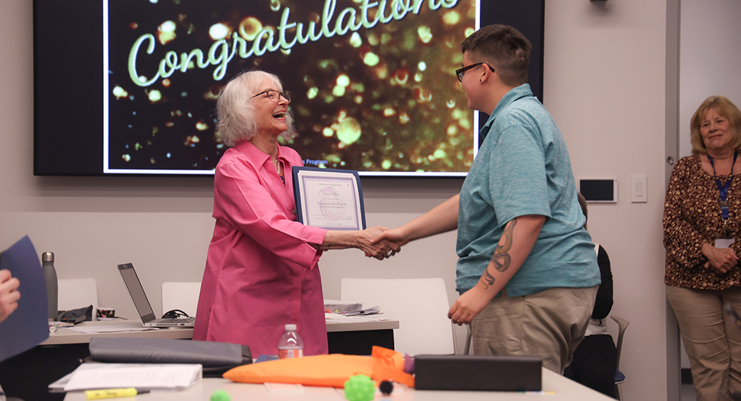 Cainan, emerging leader program graduate, accepting certificate from program leader, Georgi.