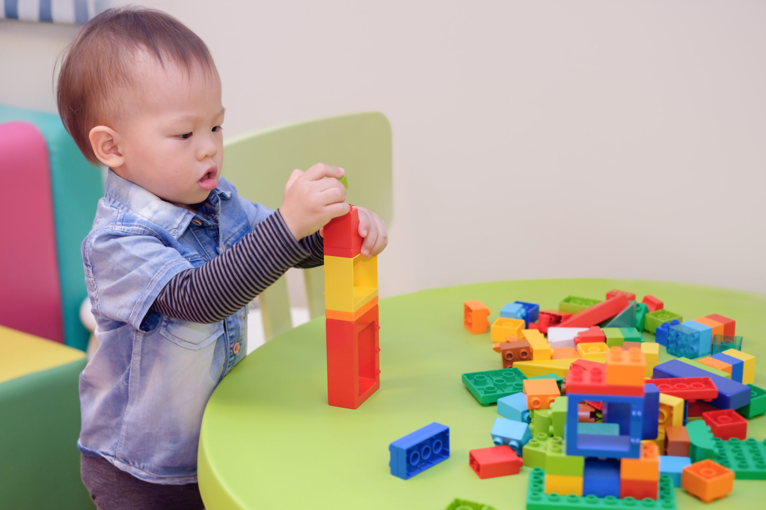 toddler boy stacking colorful blocks