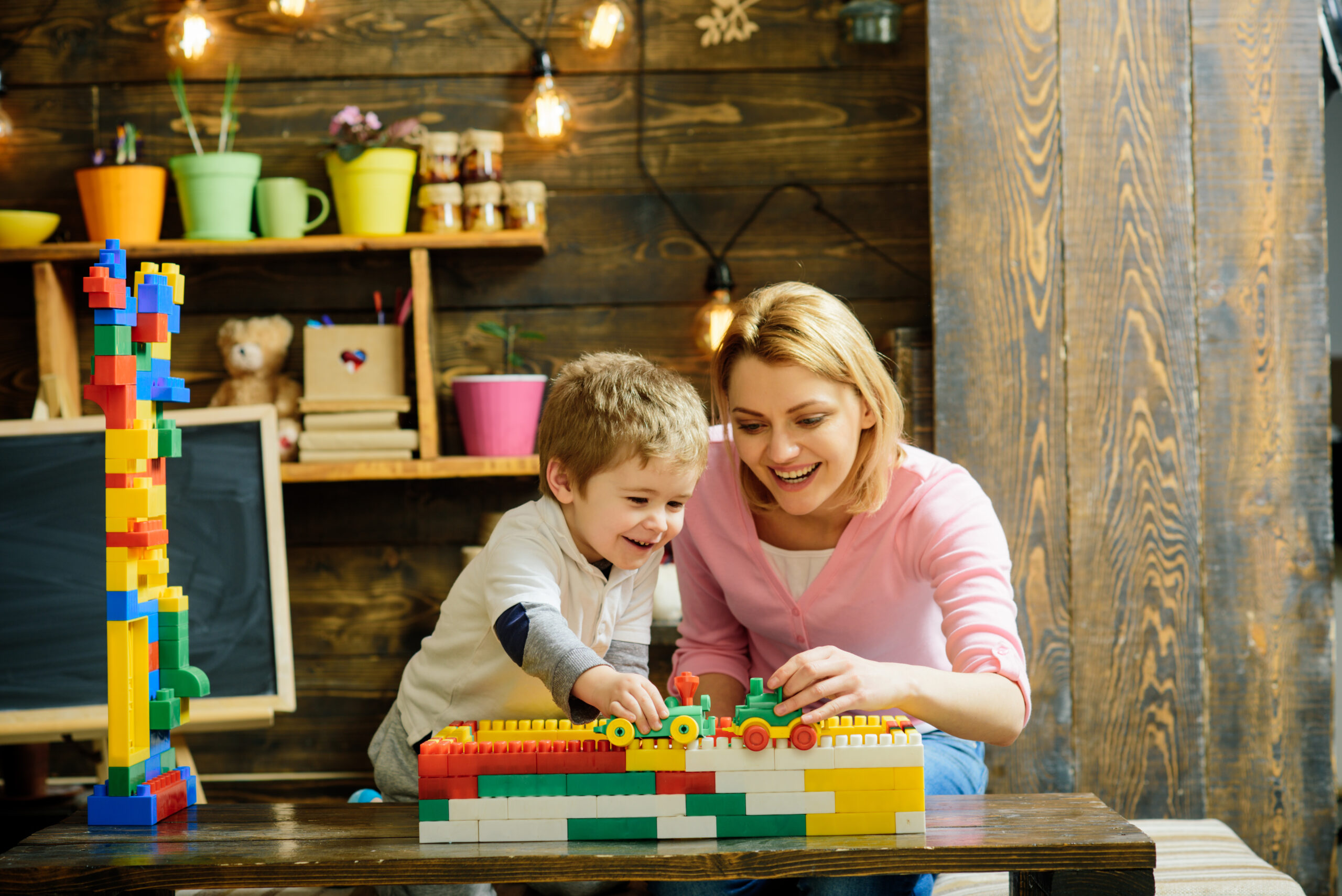 mother and son running a toy car over stackable blocks