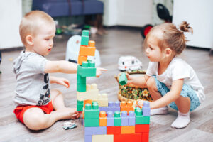 2 toddlers playing blocks together