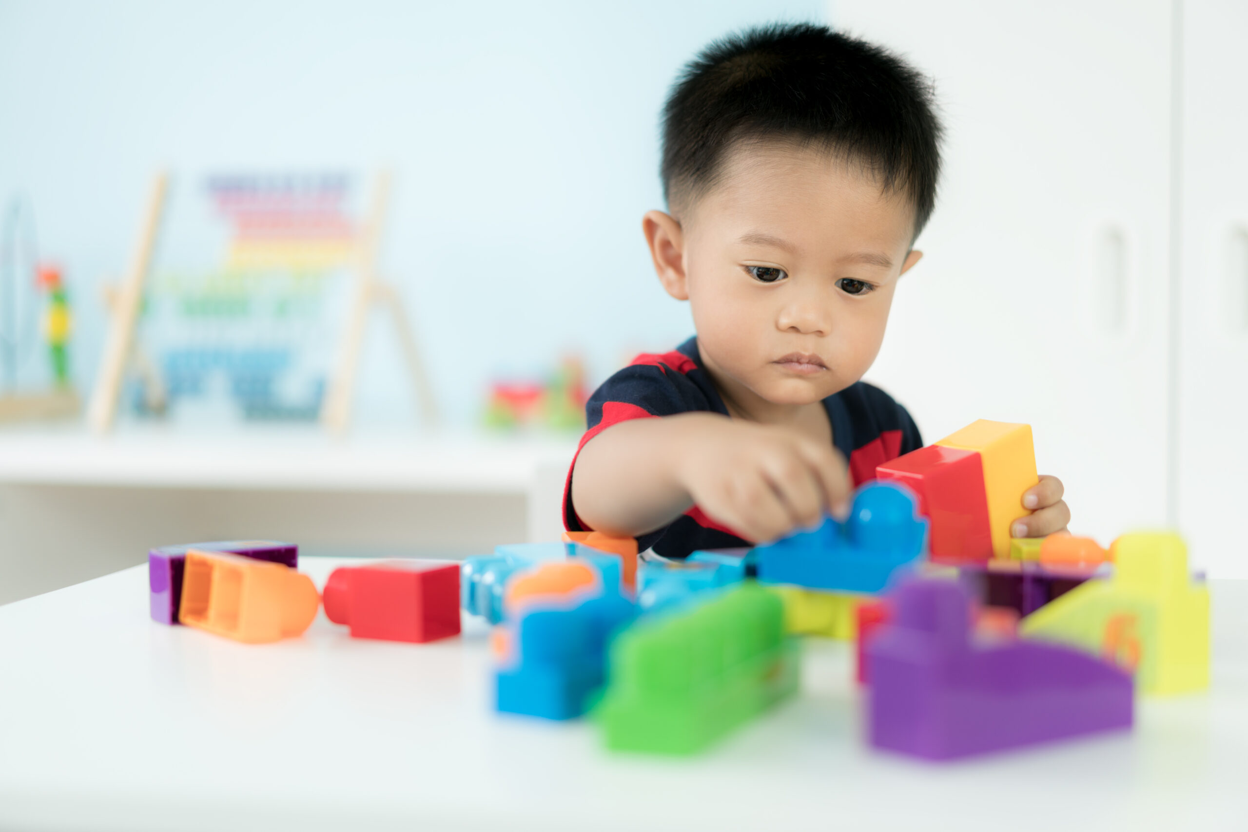 young boy playing with stackable blocks