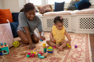 Smiling mom using blocks to help baby learn