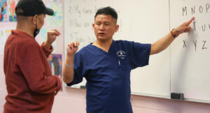 Yam teaching sign language at Intra-National Homecare.