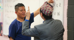 Yam teaching sign language at Intra-National Homecare.
