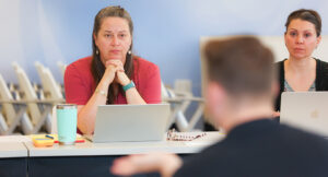 Photo of Chris Watts speaking with a colleague during the Intensive Treatment Team meeting.