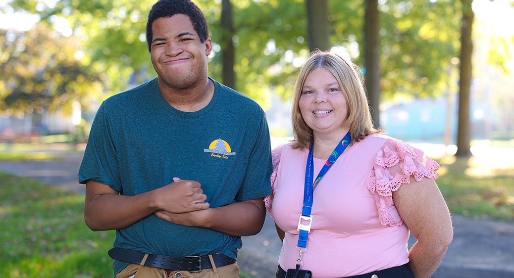 Maliek and Summit DD SSA Angie Collier posing proudly for a photo at a Cuyahoga Falls parks and recreation location.