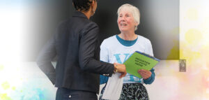 Picture of women helping another women register to vote.