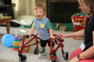 Smiling toddler standing using his adaptive stander