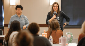 Image of a presenter in front of a crowd at the Summit DD EI Autism event.