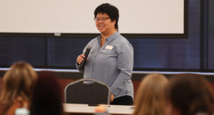 Image of a presenter in front of a crowd at the Summit DD EI Autism event.