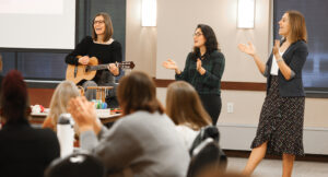Image of a presenter in front of a crowd at the Summit DD EI Autism event.