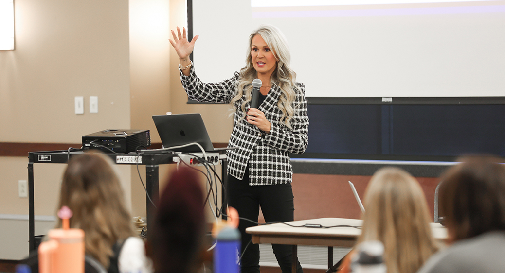 Image of a presenter in front of a crowd at the Summit DD EI Autism event.