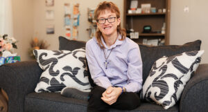 Photo of Evan sitting on the Smart Home couch smiling proudly.