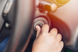 closeup hand twist turn car key to start ignite engine for drive.