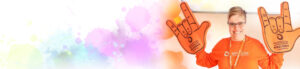 Image of smiling woman wearing orange for inclusion and holding up 2 foam hands in the ASL sign of Love