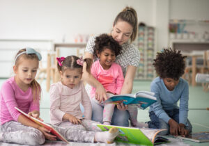 Teacher reading to 4 young children for story time