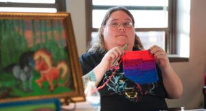 Artist Amanda posing with her work at the 2025 Art Walk.