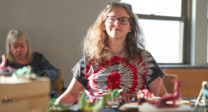 Portrait of artist Elizabeth in front of her sculptures at the Summit Art Walk.