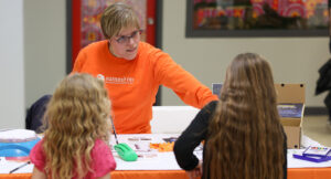 Photo of Summit DD team member Jessica showing small children assistive technology options.