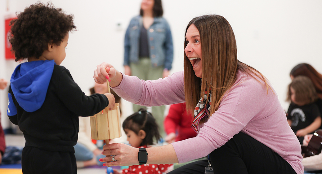 Summit DD Developmental Specialist playing with child during Music Therapy class.