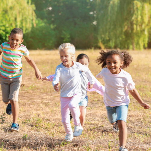Group of young kids smiling and running towards the camera