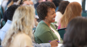 An audience member smiling at the Summit DD Home Visit Safety Training.