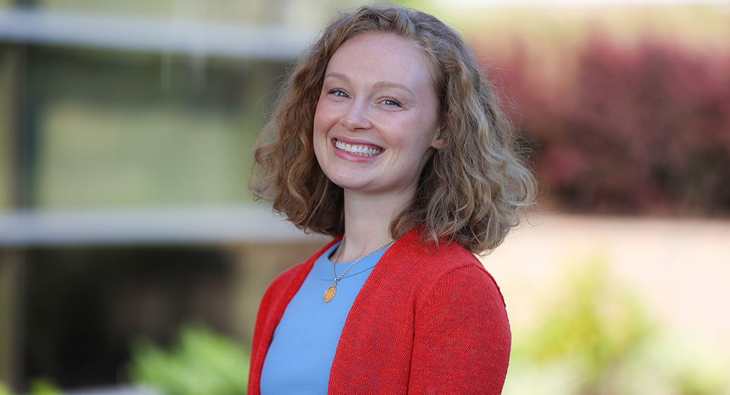 Portrait of new Summit DD staff member, Jenna Fisher, smiling in front of the Summit DD office building.