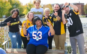Group photo of football fans waving and giving thumbs up