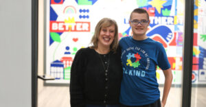 Female staff member posing for a picture with a young man at Summit DD's 2025 Early Intervention Autism Summit.