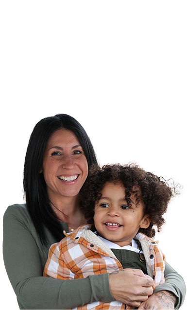 Mother and small son smiling while embracing each other.